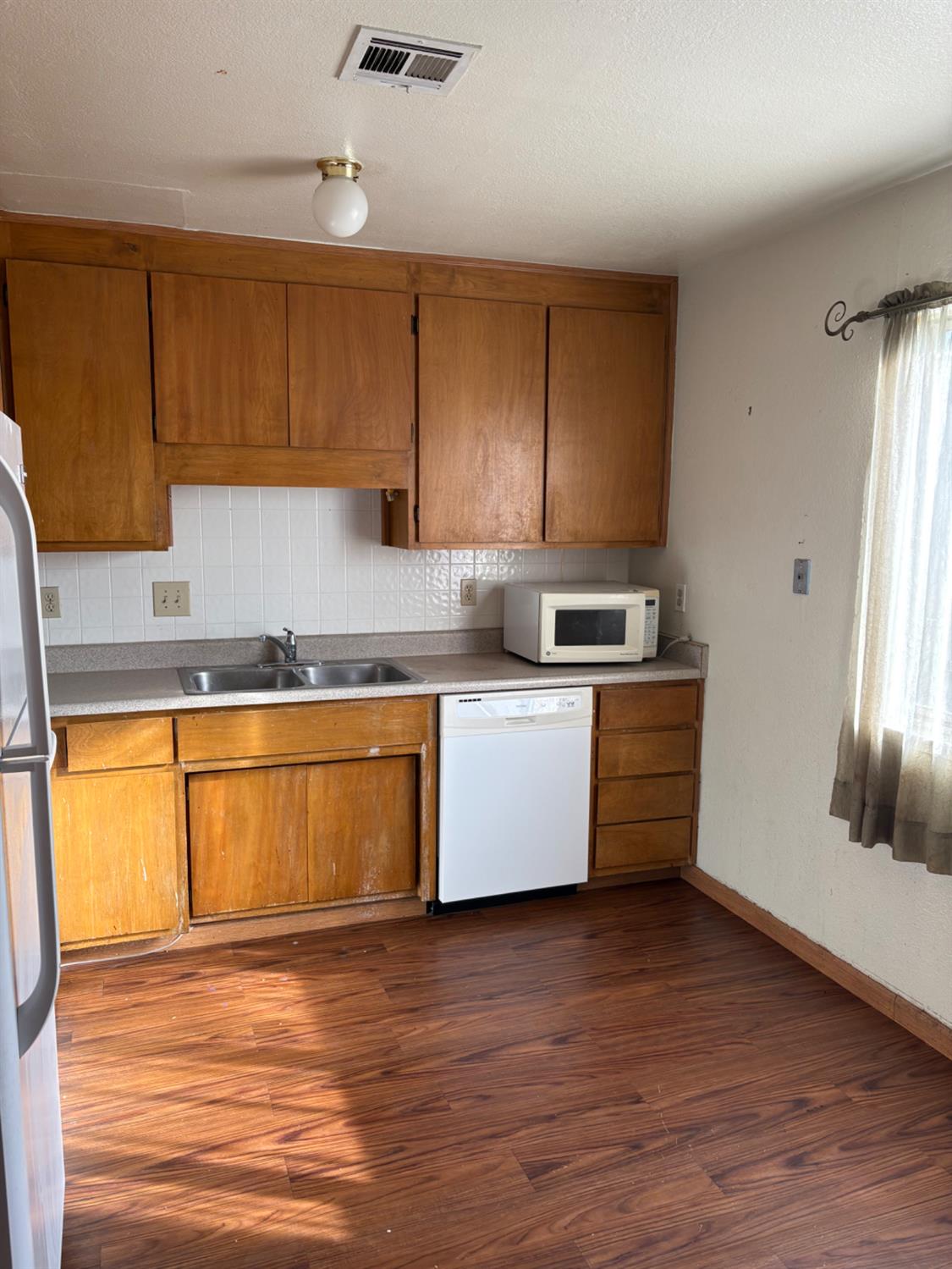 206 West 12th Street Tracy, CA 95376 - Photo 14 of 17 a kitchen with stainless steel appliances granite countertop a sink a stove a refrigerator with grey cabinets
