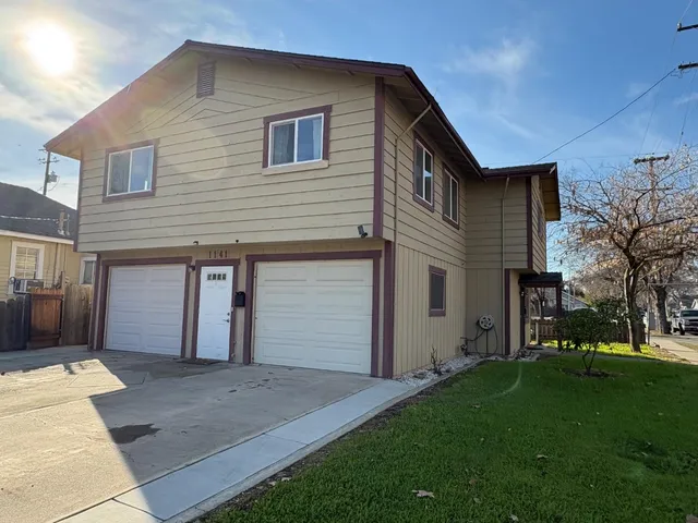 a front view of a house with a garden and yard