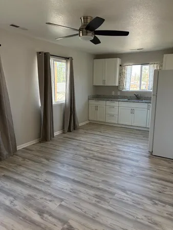 a view of an empty room with a window and wooden floor