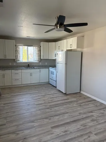 a large kitchen with cabinets wooden floor and stainless steel appliances