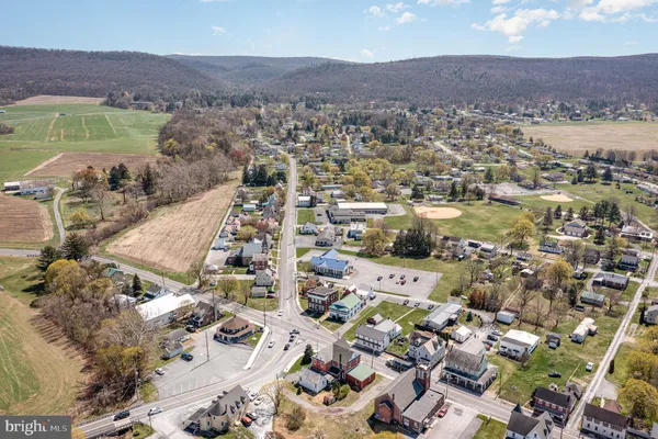 an aerial view of a city with lots of residential buildings ocean and mountain view in back