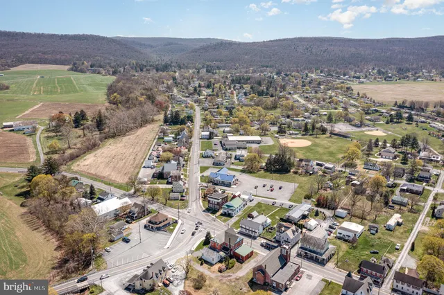 an aerial view of a city with lots of residential buildings ocean and mountain view in back