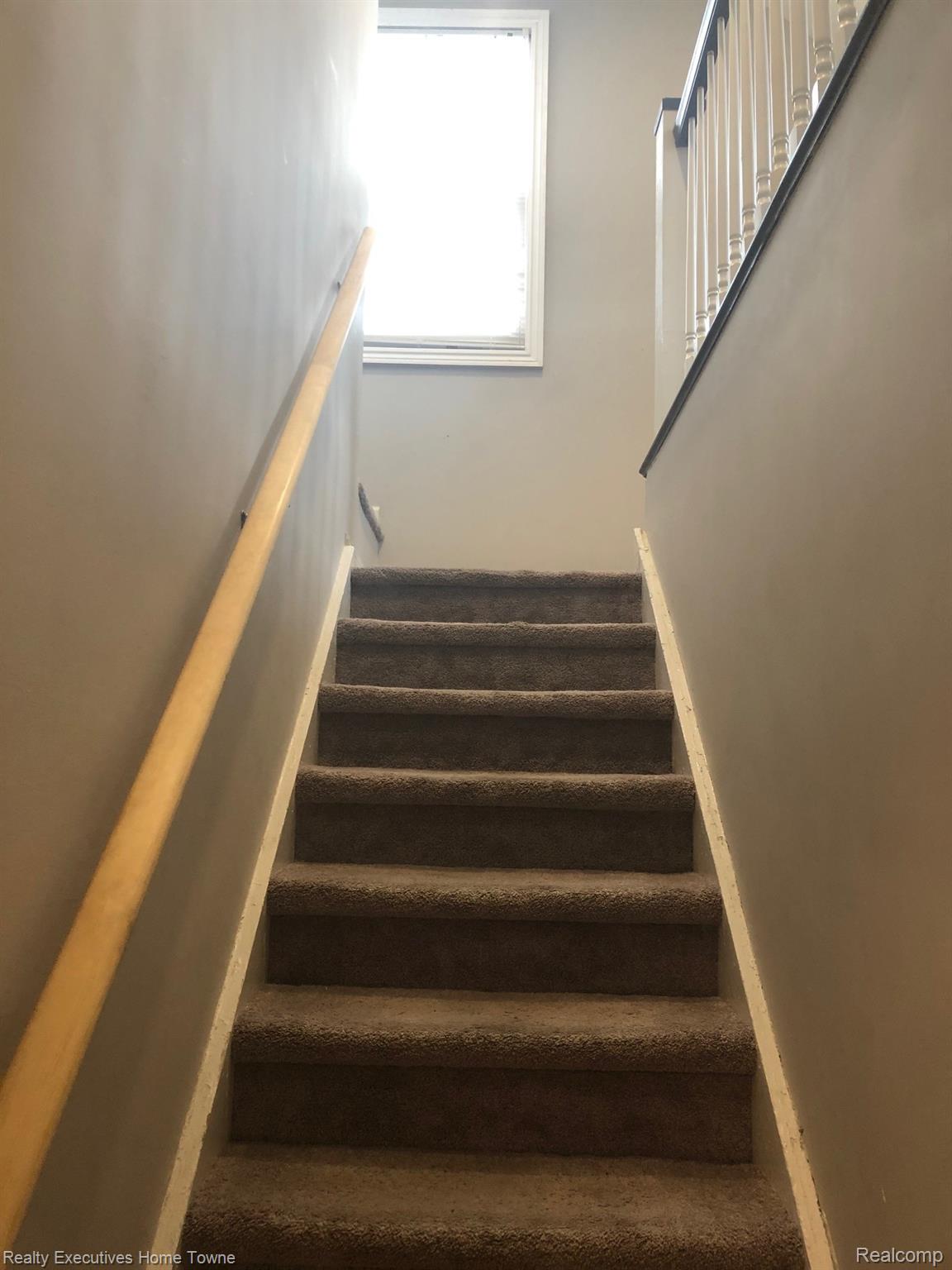 2427 Cambridge Road Berkley, MI 48072 - Photo 15 of 17 Carpeted staircase featuring a light wood handrail and a white framed window