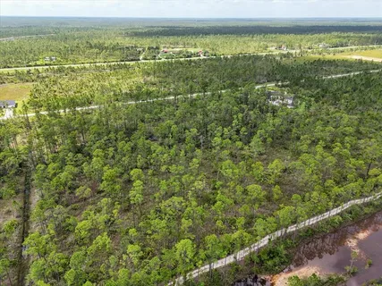 an aerial view of residential houses with outdoor space and ocean view