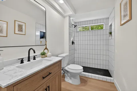 a bathroom with a granite countertop toilet sink and mirror