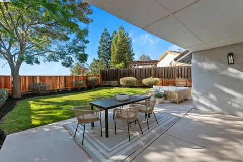 a backyard of a house with table and chairs