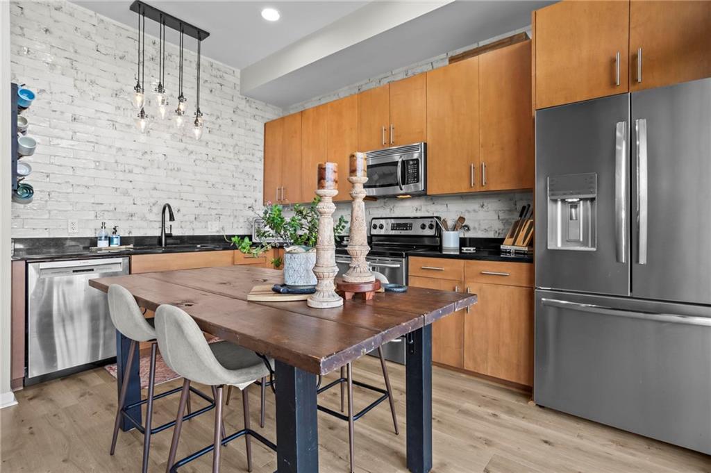 3400 Malone Drive, Unit 219 Atlanta, GA 30341 - Photo 17 of 60 a kitchen with stainless steel appliances a dining table chairs and refrigerator