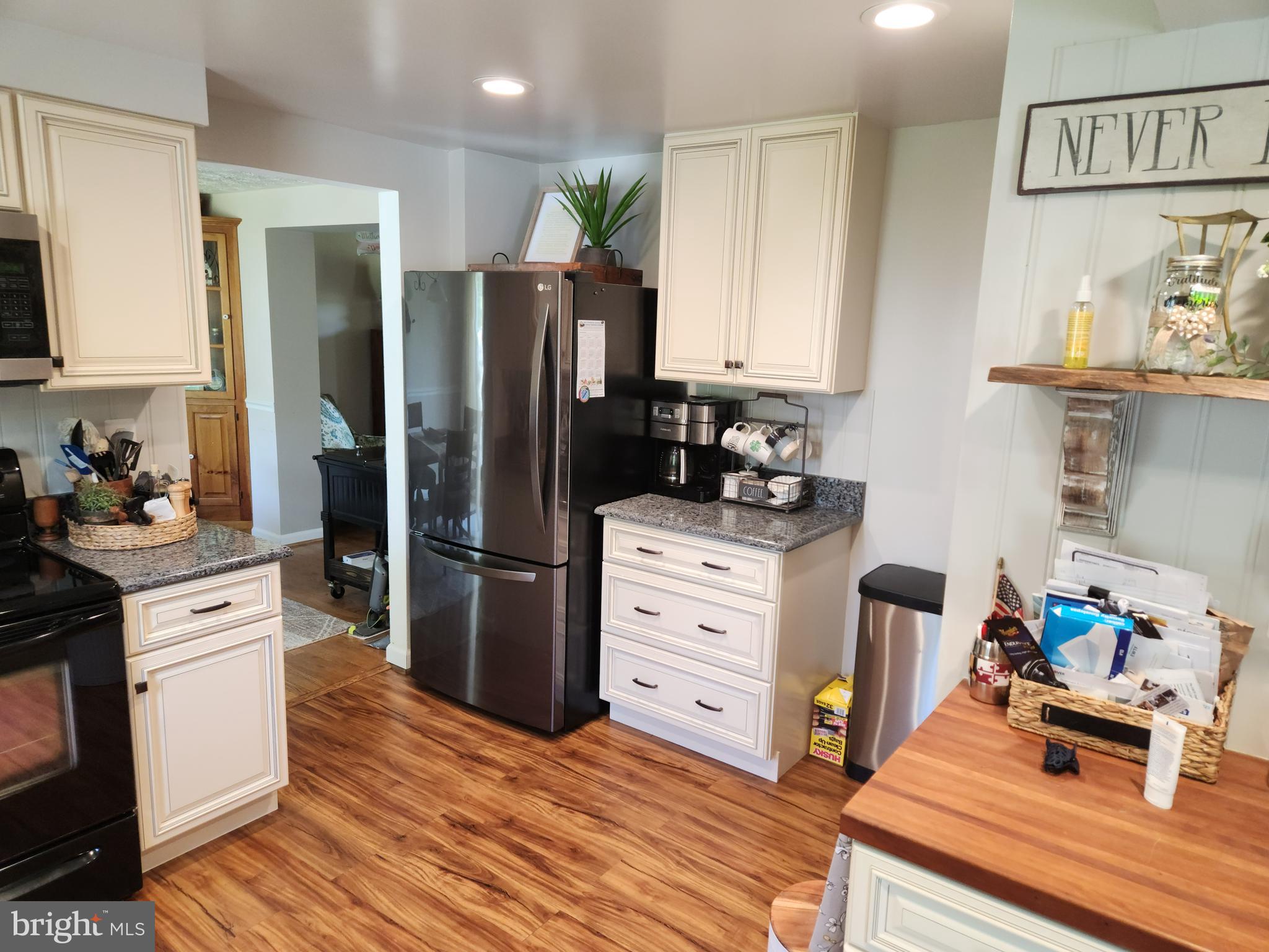 1203 Conewago Drive Frederick, MD 21702 - Photo 5 of 24 a kitchen with stainless steel appliances kitchen island granite countertop a refrigerator stove and wooden floor