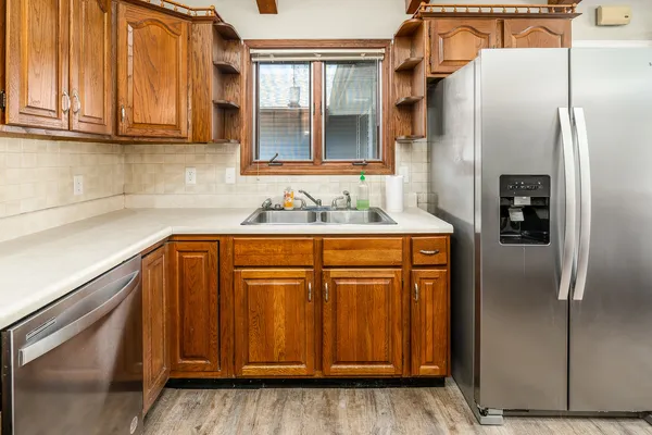 a kitchen with stainless steel appliances granite countertop a refrigerator and a sink