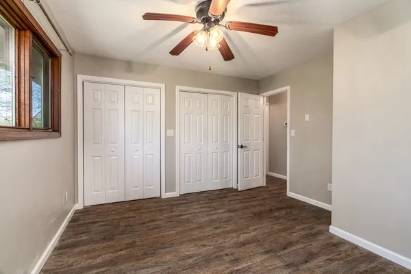 a view of a livingroom with a chandelier fan and wooden floor