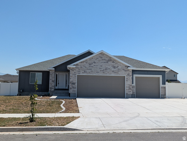 171 South Mustang Road East Grantsville, UT 84029 - Photo 32 of 41 Modern ranch-style home featuring a two-car garage, an additional single-car garage, and a light-toned stone and stucco facade