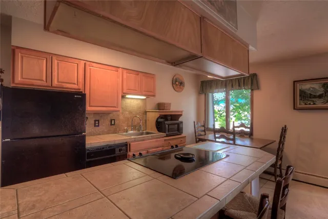 a kitchen with a table chairs and a refrigerator