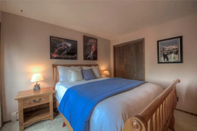 a bedroom with a bed and a lamp on dresser