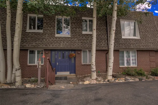 a front view of a house with a yard and parking space