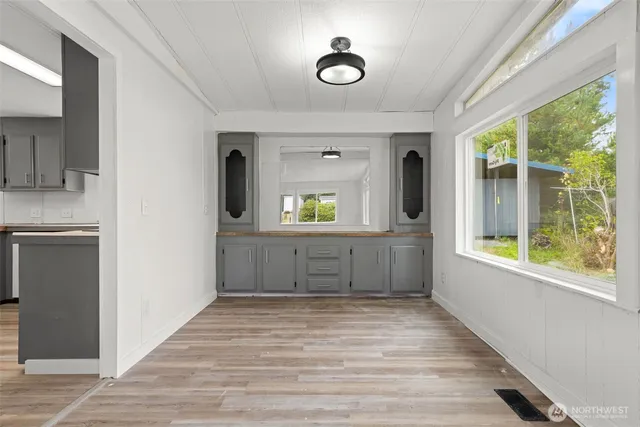 a view of a hallway with wooden floor and a living room
