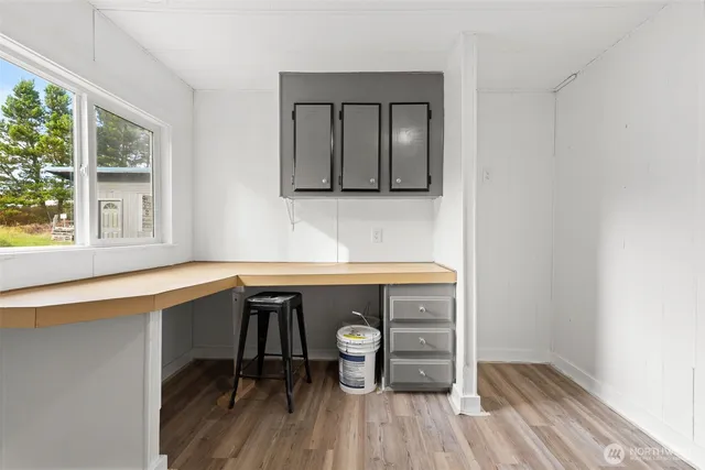 a room with a wooden floor and windows