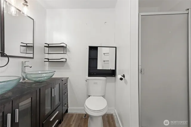 a bathroom with a granite countertop toilet a sink and a mirror
