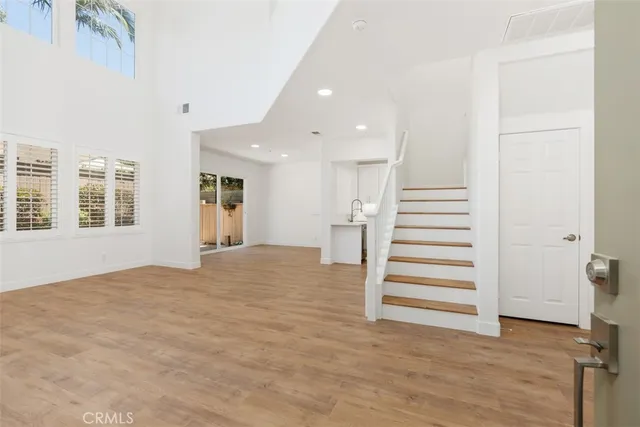 a view of a bedroom with wooden floor and stairs