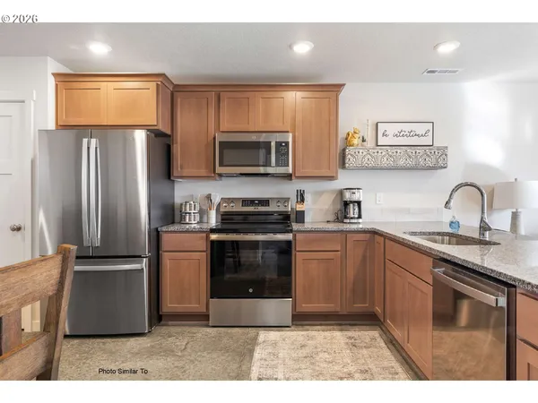 a kitchen with stainless steel appliances granite countertop a refrigerator and a stove top oven