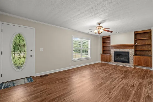 a view of a room with wooden floor and kitchen view