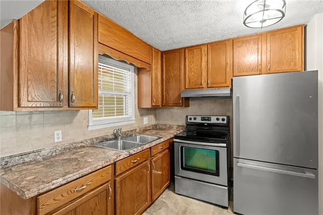 a kitchen with stainless steel appliances cabinets a sink and a refrigerator