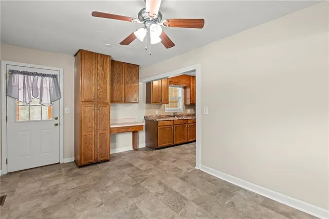a view of an empty room with wooden floor and windows