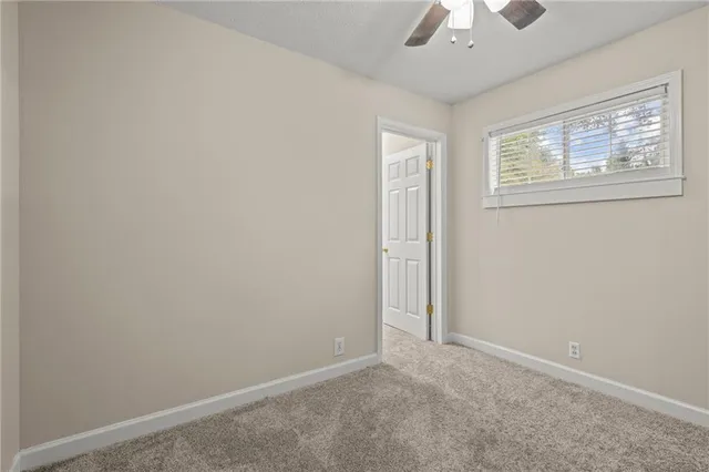 a view of a green field with trees in the background