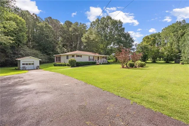 a view of a house with swimming pool and yard