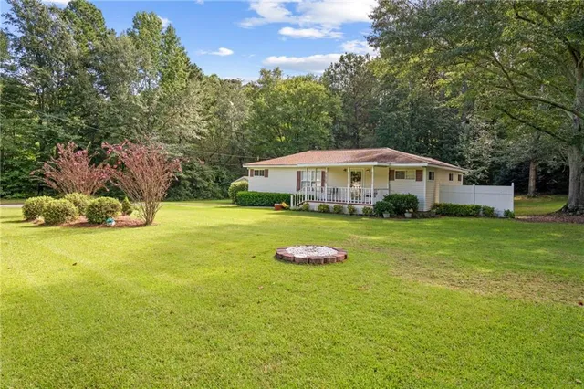 a front view of a house with a yard and potted plants