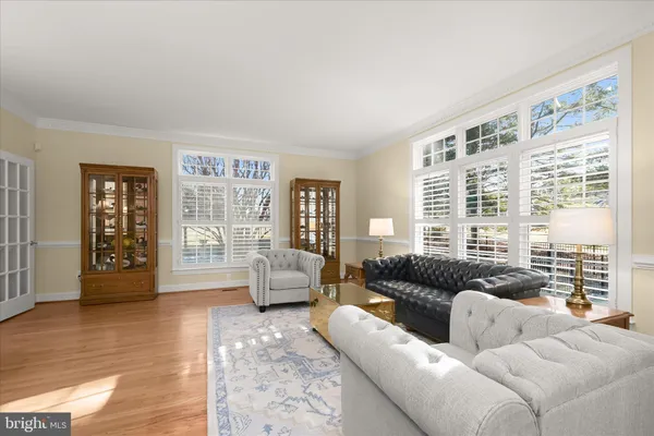 a kitchen with stainless steel appliances granite countertop a refrigerator a sink dishwasher a oven and a dining table with wooden floor