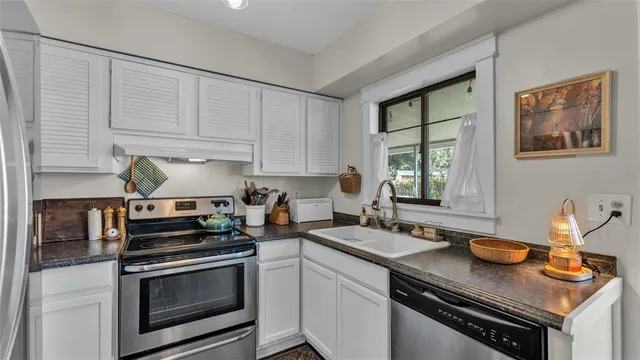 a kitchen with stainless steel appliances granite countertop a sink stove and cabinets