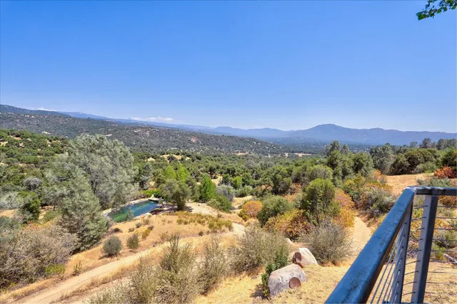 a front view of house with yard and trees in the background