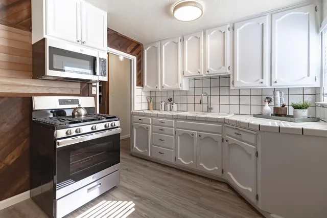 a kitchen with white cabinets and appliances