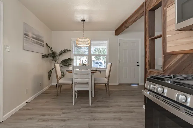 a dining room with furniture a chandelier and wooden floor