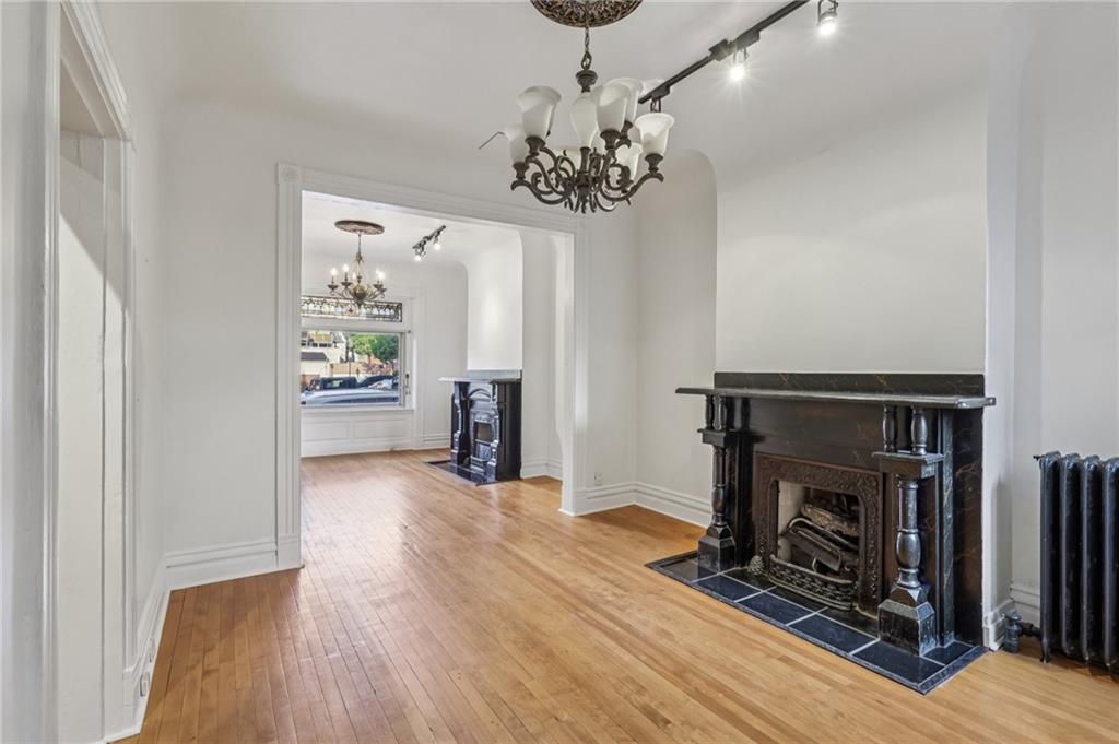 1218 Sherman Avenue Pittsburgh, PA 15212 - Photo 15 of 48 a view of an empty room with a fireplace wooden floor and a window