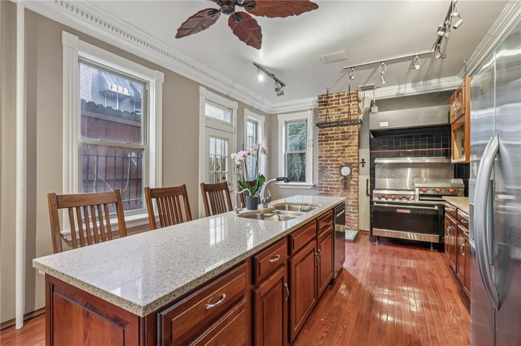 1218 Sherman Avenue Pittsburgh, PA 15212 - Photo 20 of 48 a kitchen with stainless steel appliances granite countertop a kitchen island a stove a sink a dining table and chairs