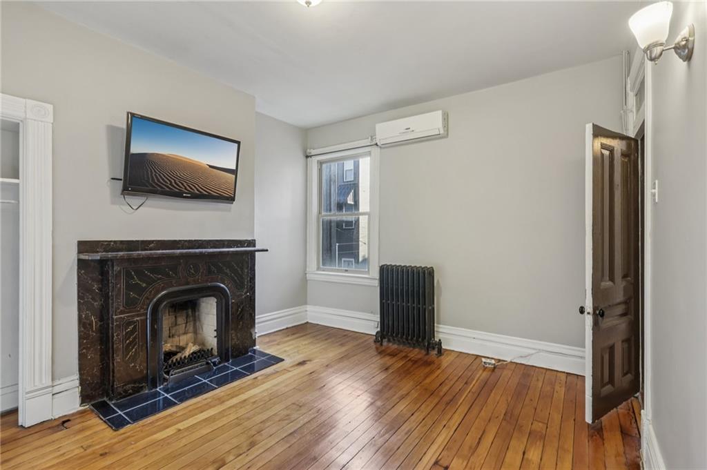 1218 Sherman Avenue Pittsburgh, PA 15212 - Photo 30 of 48 a living room with wooden floor and a fireplace