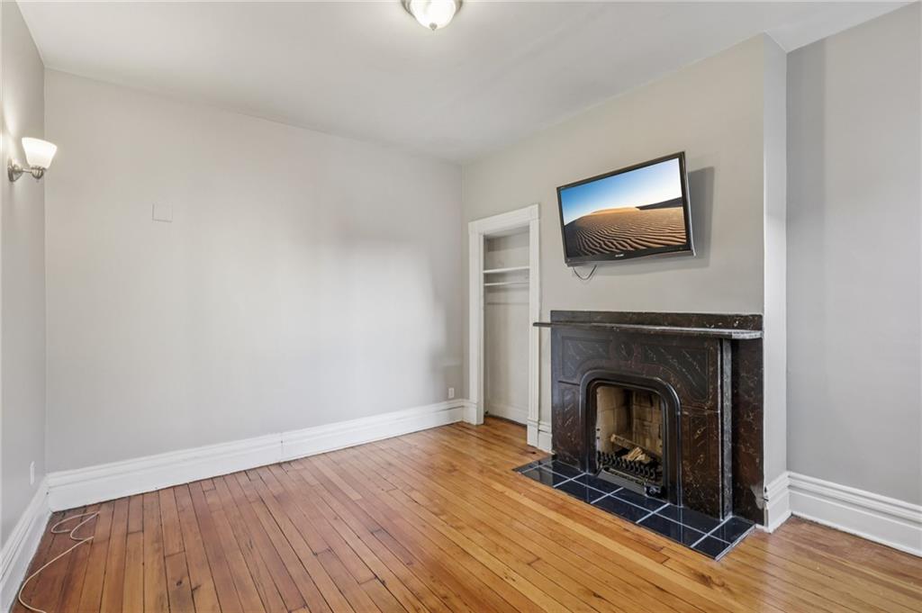 1218 Sherman Avenue Pittsburgh, PA 15212 - Photo 31 of 48 a living room with a fireplace and a flat screen tv