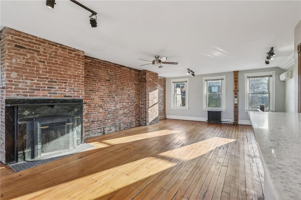 1218 Sherman Avenue Pittsburgh, PA 15212 - Photo 39 of 48 a view of an empty room with wooden floor and a fireplace