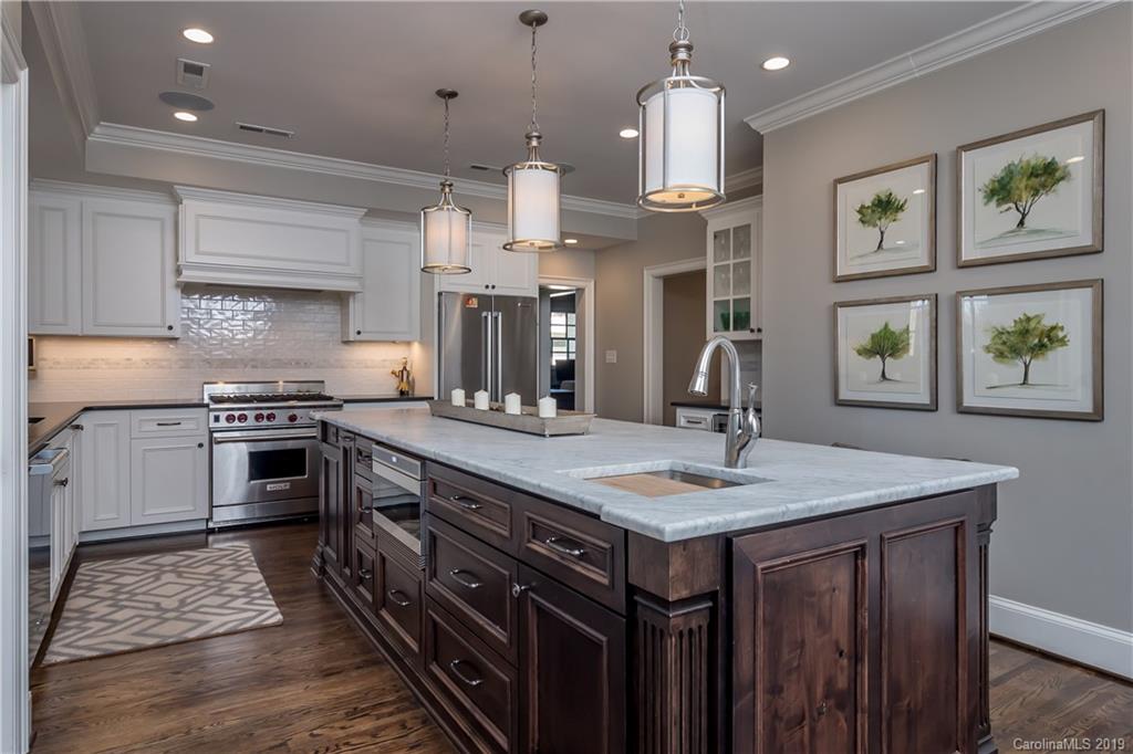 2634 Sharon Road Charlotte, NC 28211 - Photo 11 of 46 a kitchen with a stove a sink a center island and a window