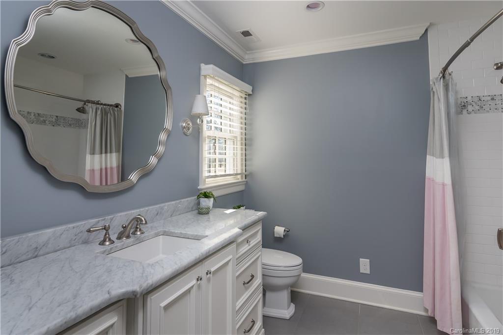 2634 Sharon Road Charlotte, NC 28211 - Photo 32 of 46 a bathroom with a granite countertop toilet a sink and a mirror