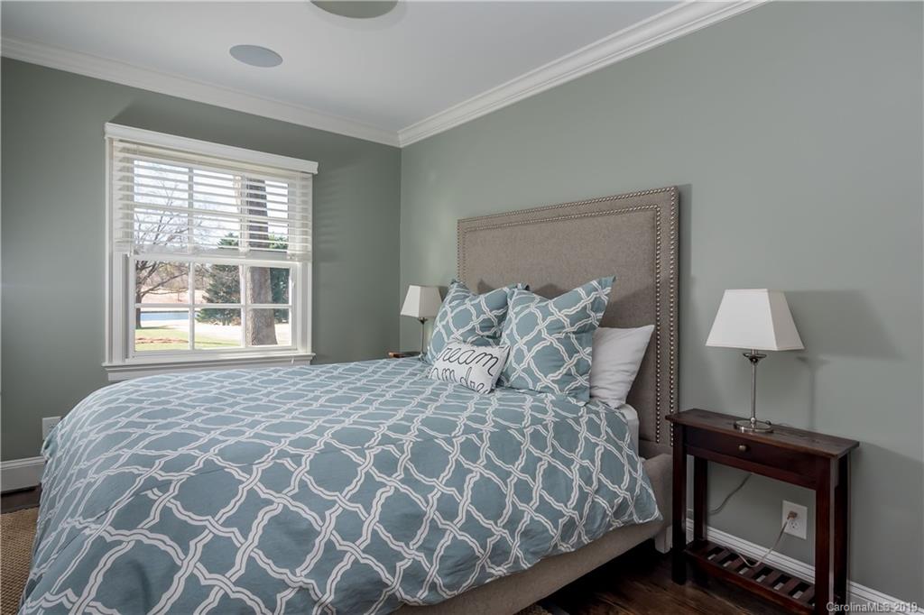 2634 Sharon Road Charlotte, NC 28211 - Photo 34 of 46 a large bed sitting in a bedroom next to a window with lamp