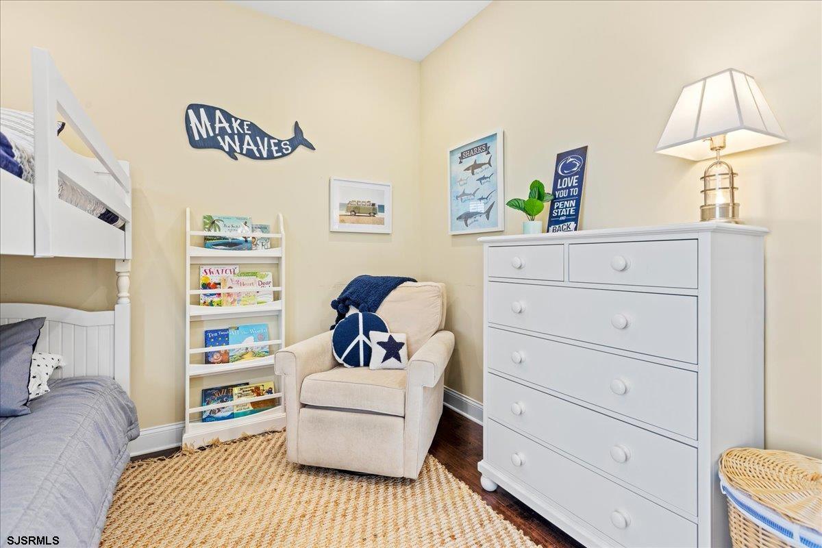 a bedroom with a bed and a lamp on dresser