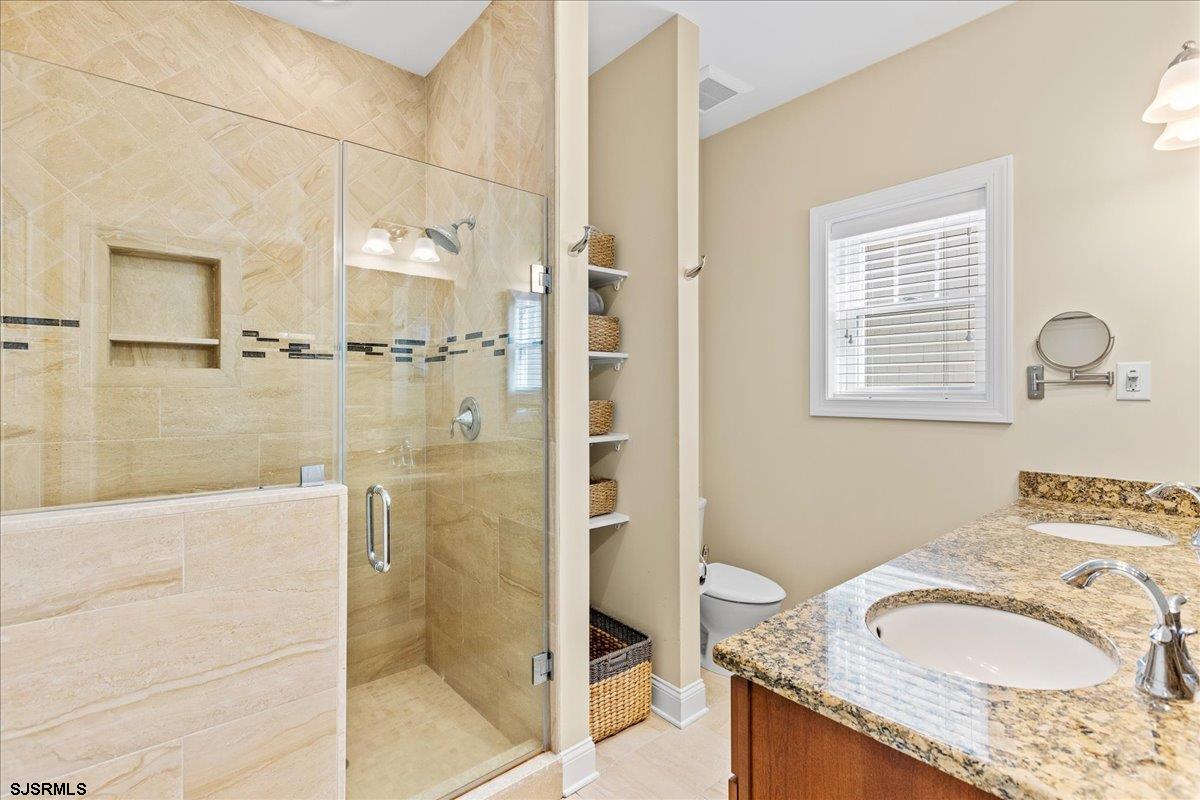 16 South Decatur Avenue Margate City, NJ 08402 - Photo 32 of 53 a bathroom with a granite countertop sink a mirror and a shower