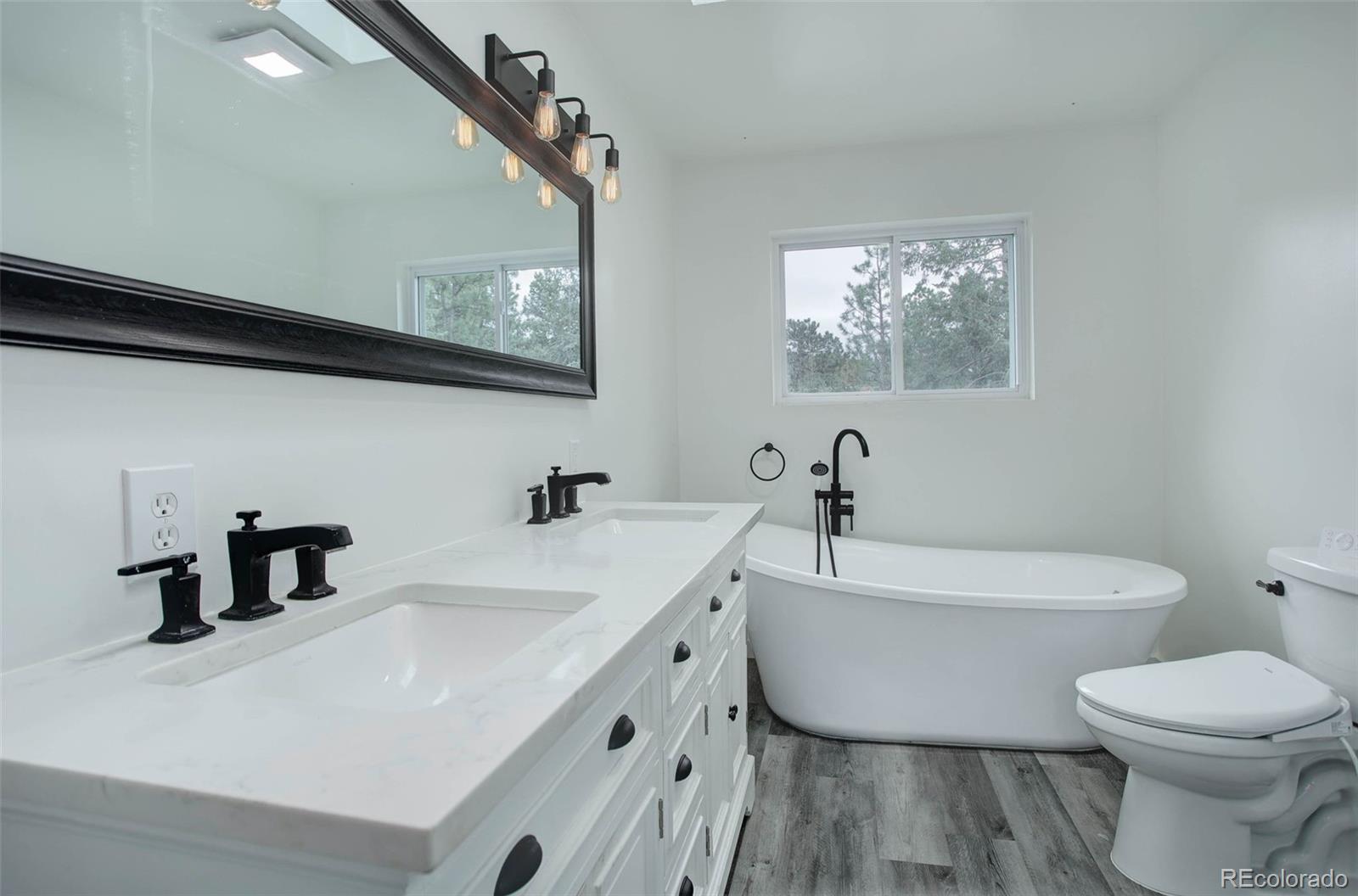 27857 Apex Circle Evergreen, CO 80439 - Photo 11 of 37 a bathroom with a toilet a sink and mirror