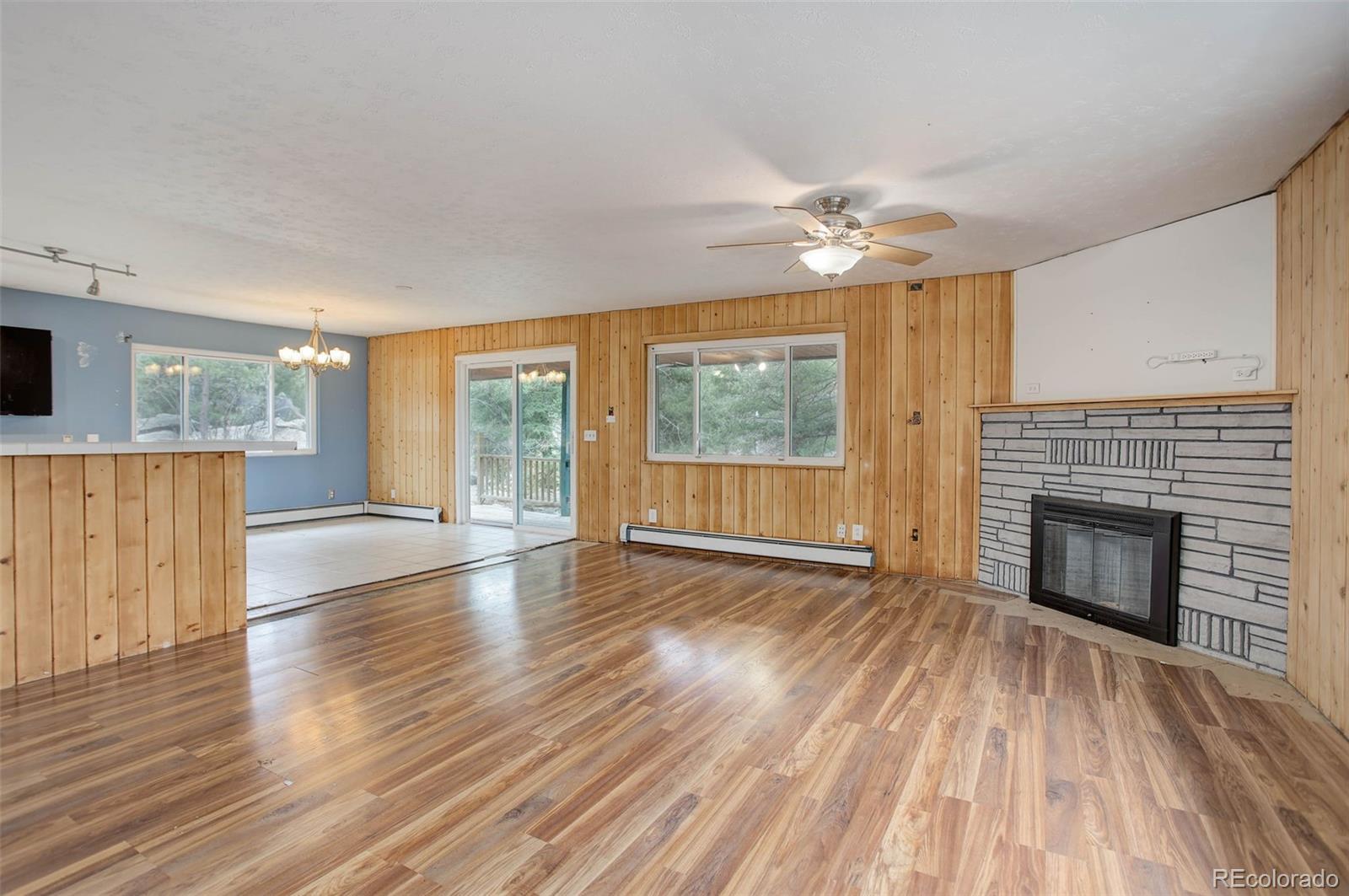 27857 Apex Circle Evergreen, CO 80439 - Photo 4 of 37 an empty room with wooden floor fireplace and windows