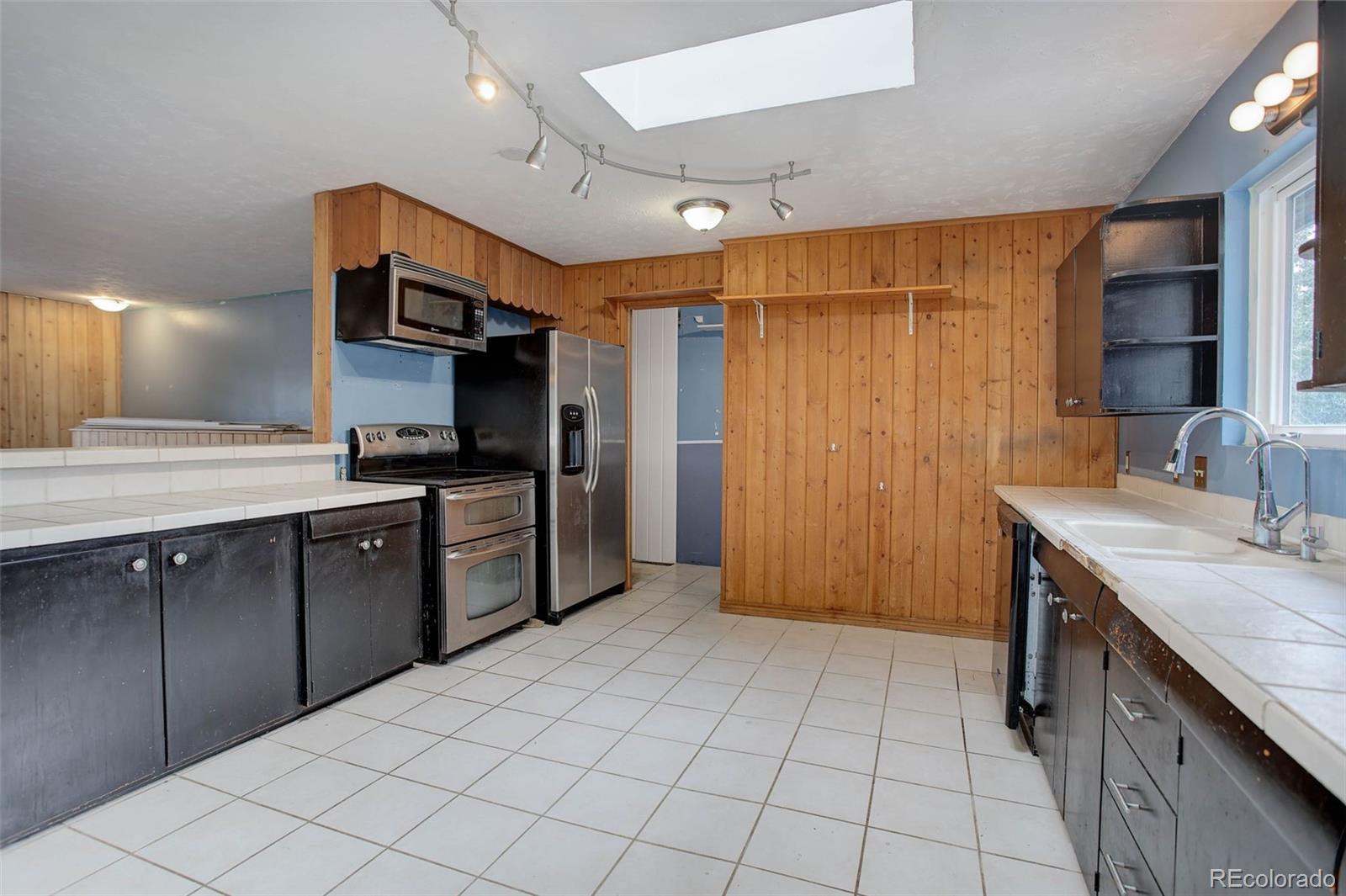 27857 Apex Circle Evergreen, CO 80439 - Photo 9 of 37 a kitchen with stainless steel appliances kitchen island granite countertop a refrigerator and a sink