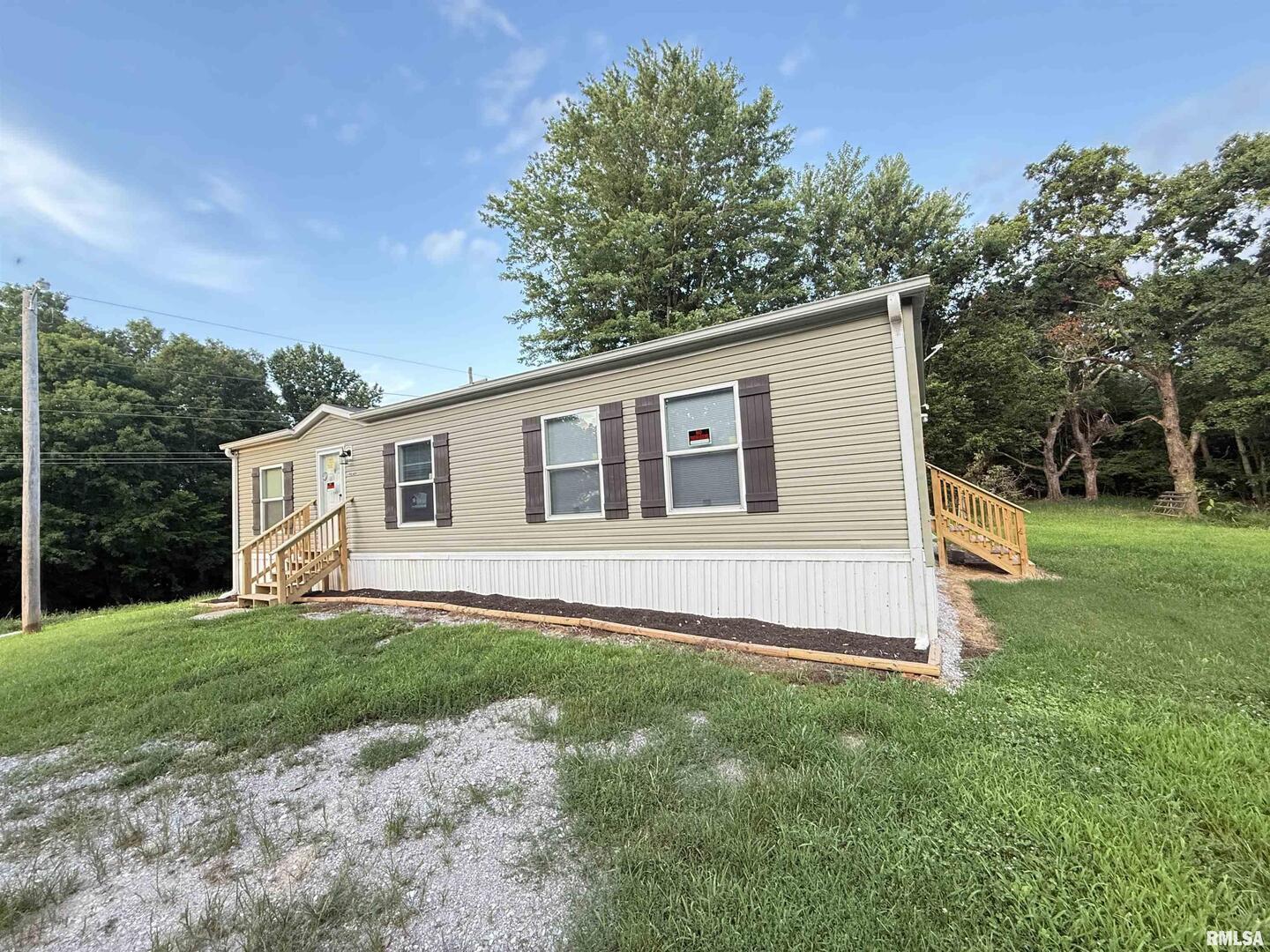 9049 Grassy Road Marion, IL 62959 - Photo 30 of 45 a front view of a house with a yard and trees