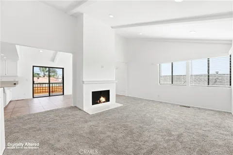 an empty room with windows and fireplace