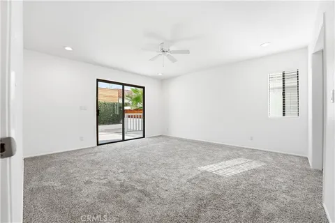 an empty room with windows and ceiling fan